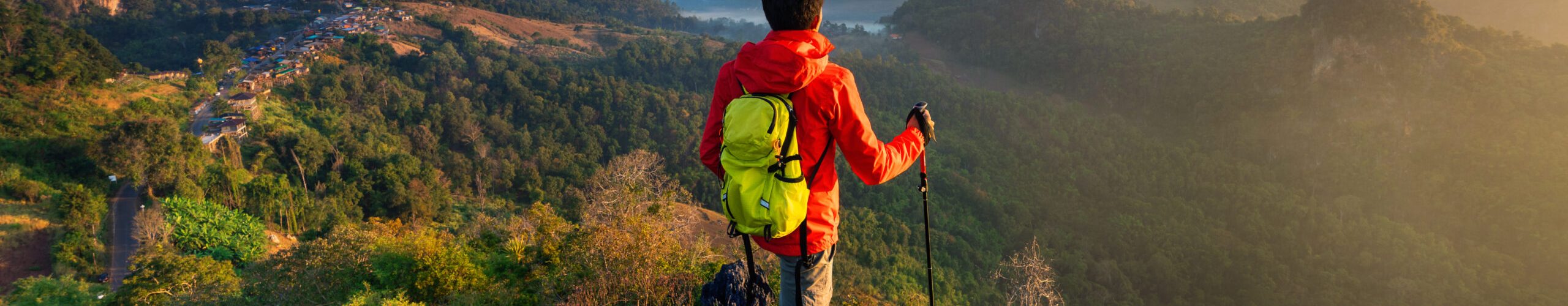 Backpacker standing on sunrise viewpoint at Ja Bo village, Mae hong son province, Thailand.